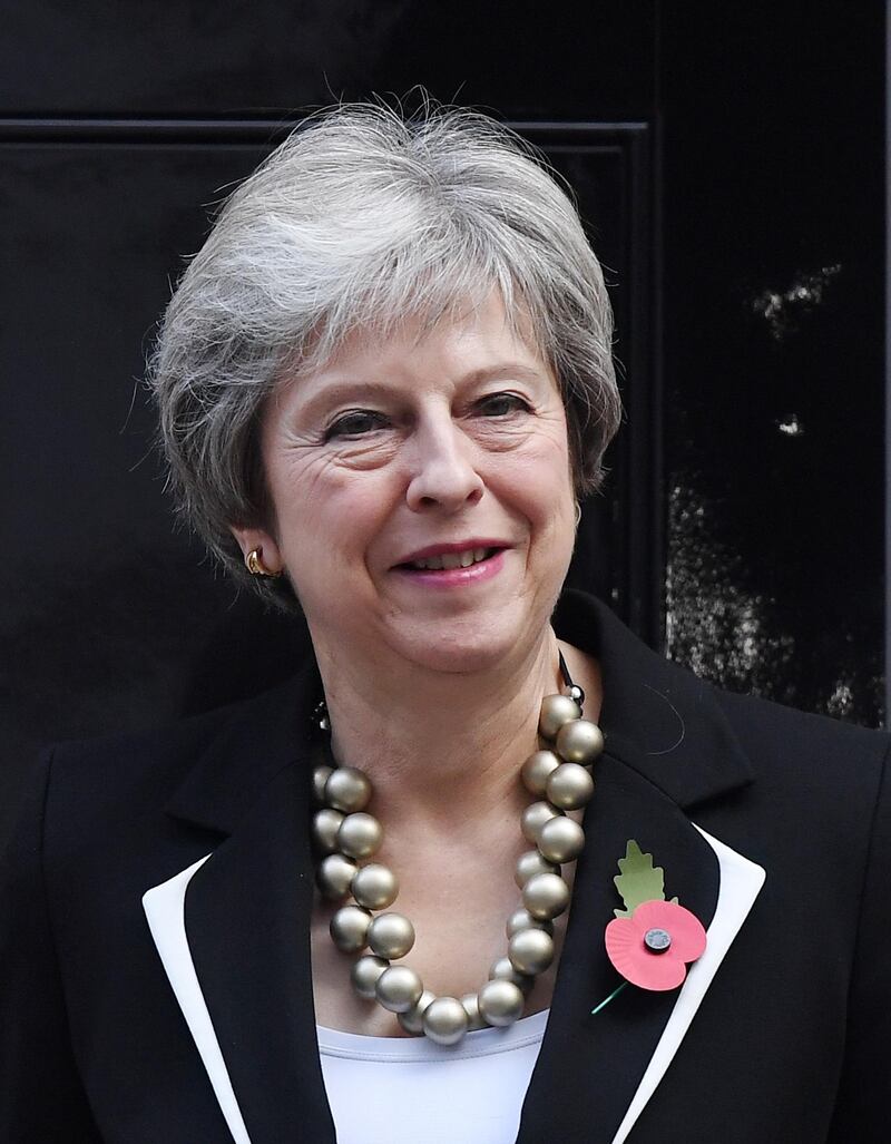 epa07118320 British Prime Minister Theresa May smiles during the launch of the Poppy Appeal at No. 10 Downing Street in London, Britain, 25 October 2018. May has seemingly survived a meeting of the party’s 1922 Committee following an emotional speech to party back benchers at the Commons 24 October.  EPA/ANDY RAIN