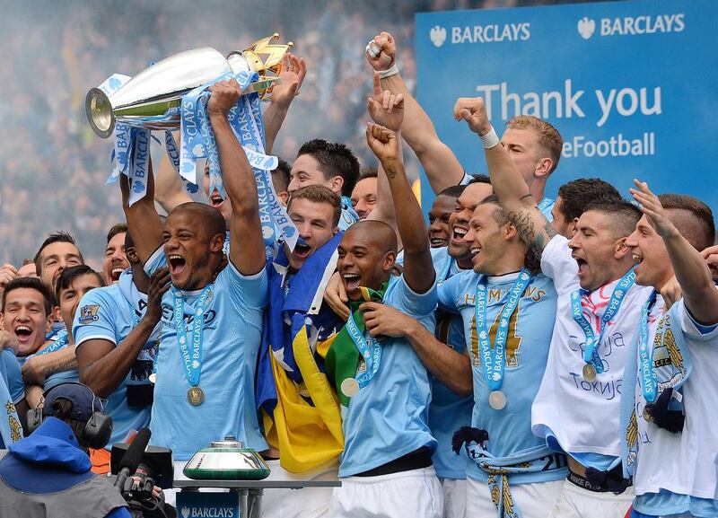 Manchester City's Vincent Kompany celebrates with the trophy after his team won the English Premier League title with their victory over West Ham United at the Etihad Stadium in Manchester on May 11, 2014. Andrew Yates / AFP