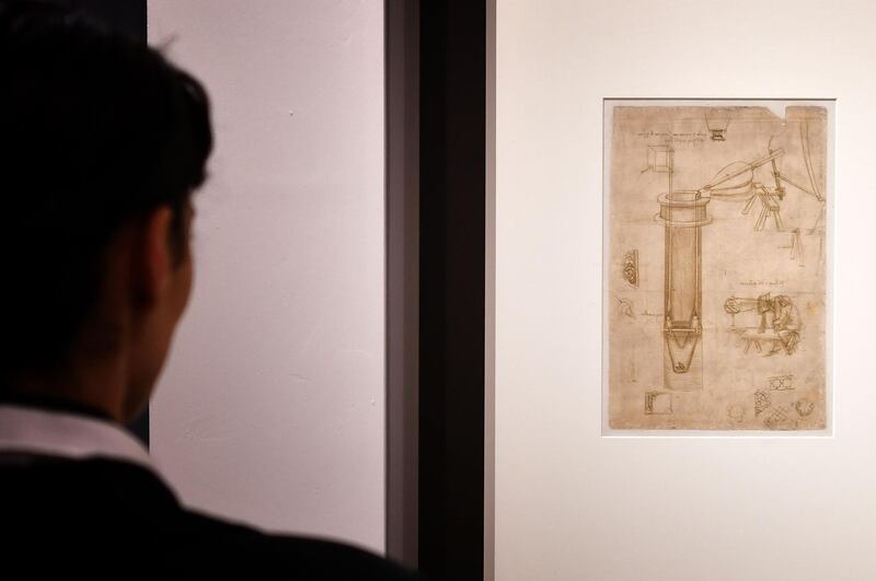 A visitor watches Leonardo da Vinci's "Study for a hydraulic pump, man with a perspectograph (Codex Atlanticus)" during the exhibition "Science Before Science" (La Scienza prima della Scienza) on March 12, 2019 at the Scuderie del Quirinale palace in Rome. / AFP / Alberto PIZZOLI
