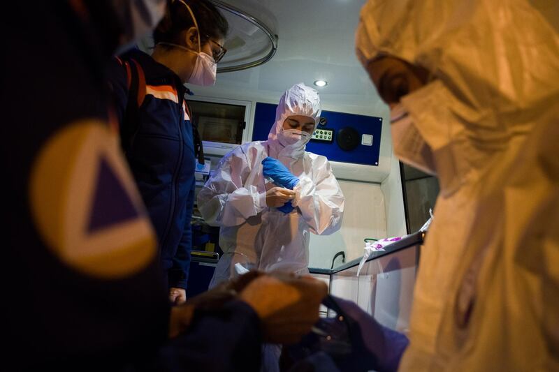 Civil Protection ambulance crew fit personal protective equipment before attending to a patient inside an ambulance in Paris. Bloomberg