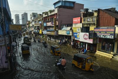 People commute through a waterlogged road following incessant heavy rains in Chennai. EPA