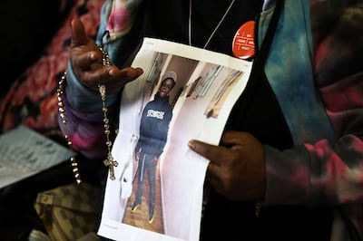 Rebecca Turnage joins other families at Where Do We Go From Here to drop of memorabilia for the Gun Violence Memorial Project on November 11. Ms Turnage holds a rosary and photo of her 16-year old son Jaden, who was murdered in September. Getty Images / AFP
