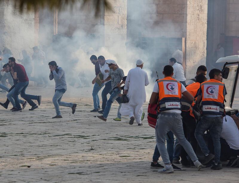 Palestinian worshippers run for cover during clashes with Israeli riot police at the Al-Aqsa Mosque compound. EPA/Fayiz Abu Rmeleh