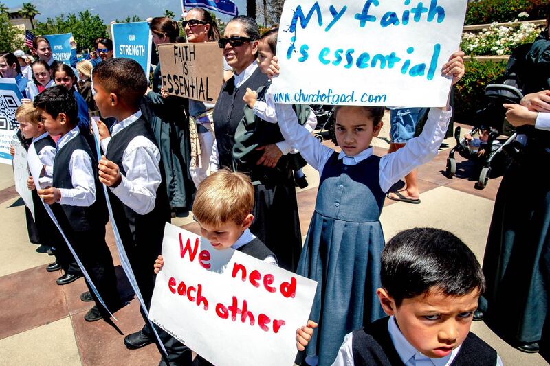 Young members of the Church of God hold signs during a demonstration against California's stay-at-home orders that were put in place due to the coronavirus outbreak, in Rancho Cucamonga. AP