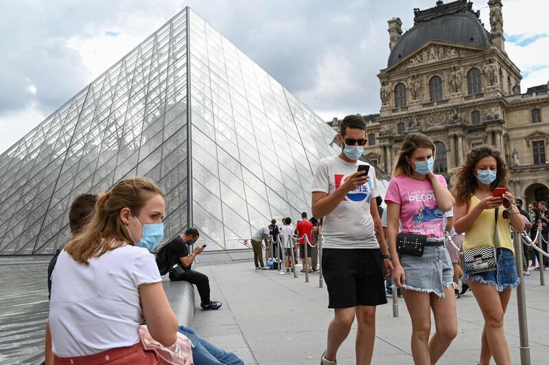 (FILES) In this file photo taken on August 15, 2020 Tourists wearing protective face masks walk past the Louvre Pyramid (Pyramide du Louvre) designed by Ieoh Ming Pei, at the Cour Napoleon, in Paris. French Prime Minister Jean Castex announced on June 16, 2021 that masks will be no longer compulsory outside in France from June 17, 2021. - RESTRICTED TO EDITORIAL USE - MANDATORY MENTION OF THE ARTIST UPON PUBLICATION - TO ILLUSTRATE THE EVENT AS SPECIFIED IN THE CAPTION
 / AFP / BERTRAND GUAY / RESTRICTED TO EDITORIAL USE - MANDATORY MENTION OF THE ARTIST UPON PUBLICATION - TO ILLUSTRATE THE EVENT AS SPECIFIED IN THE CAPTION
