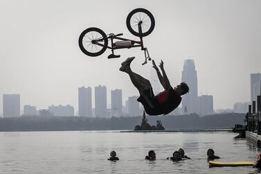 WUHAN, CHINA - AUGUST 22: (CHINA OUT)An extreme cycling enthusiast performs a stunt with a bicycle before falling into the East Lake in on August 22, 2020 in Wuhan, Hubei province, China. This activity, which requires participants to ride their bikes and jump into the lake, attracts many extreme cycling enthusiasts from the city.The event was held in 2010 and is the ten time this year. There have been no recorded cases of community transmission in Wuhan since May. Life in Wuhan returned to normal.(Photo by Getty Images)