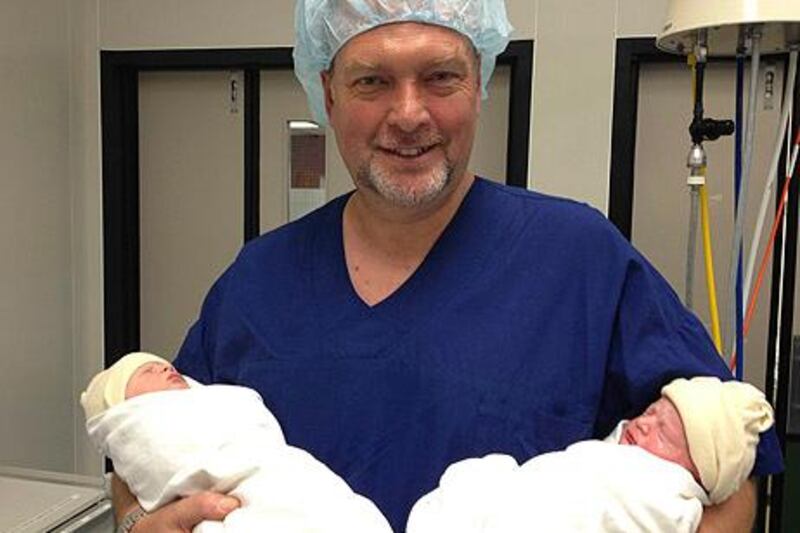 In this photo taken Wednesday, July 31, 2013 and released by Martin Weekes, Martin Weekes smiles as he holds he and his wife's twins Poppy and Parker Weekes after their birth at the North Shore Hospital in Auckland, New Zealand. The New Zealand couple whose 2-year-old triplets were killed last year in a mall fire in Qatar's capital are celebrating the birth of twins. Martin Weekes says Poppy and Parker were born Wednesday by cesarean section at 36 weeks. He says Jane and the twins are healthy and recovering well, and they all hope to return home from the hospital by next week. (AP Photo/Martin Weekes) MANDATORY CREDIT *** Local Caption ***  New Zealand Twins.JPEG-047c1.jpg