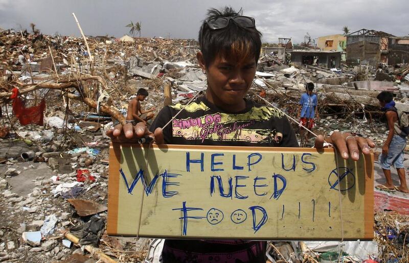 A typhoon victim asks for food while standing amongst the ruins of houses destroyed by super typhoon Haiyan in Tanauan, Leyte. Erik De Castro / Reuters

