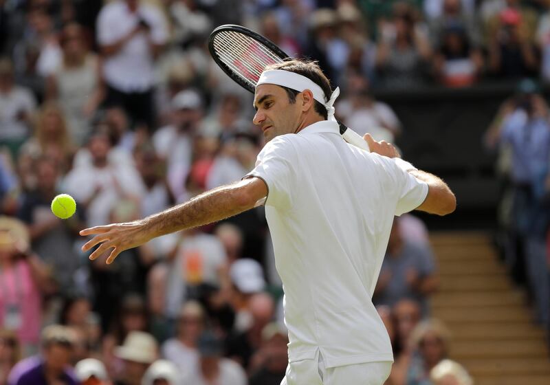 Switzerland's Roger Federer celebrates by hitting a ball into the crowd after he beat South Africa's Lloyd Harris in a Men's singles match during day two of the Wimbledon Tennis Championships in London, Tuesday, July 2, 2019. (AP Photo/Ben Curtis)