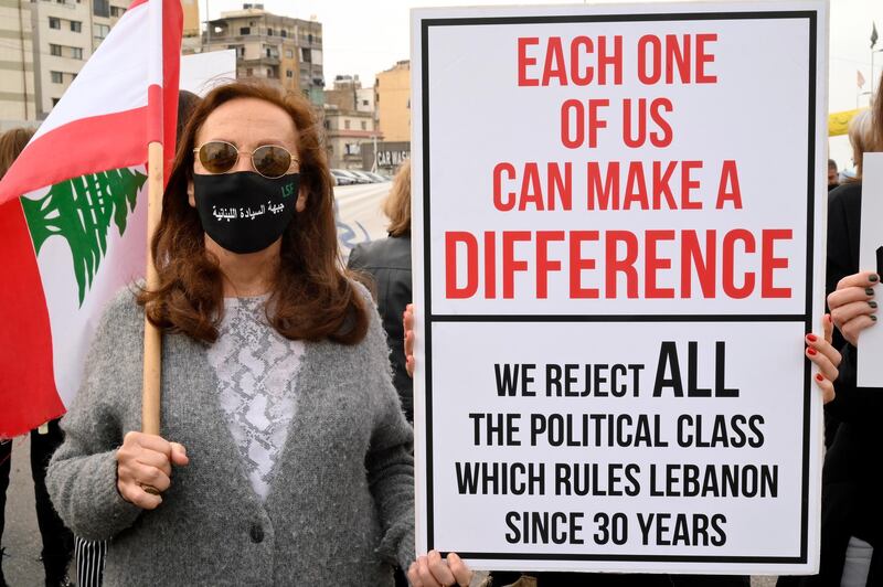 A Lebanese woman carries a placard as she marches on the occasion of Mother's Day under the slogan 'Mother's Cry', in Beirut, Lebanon. EPA