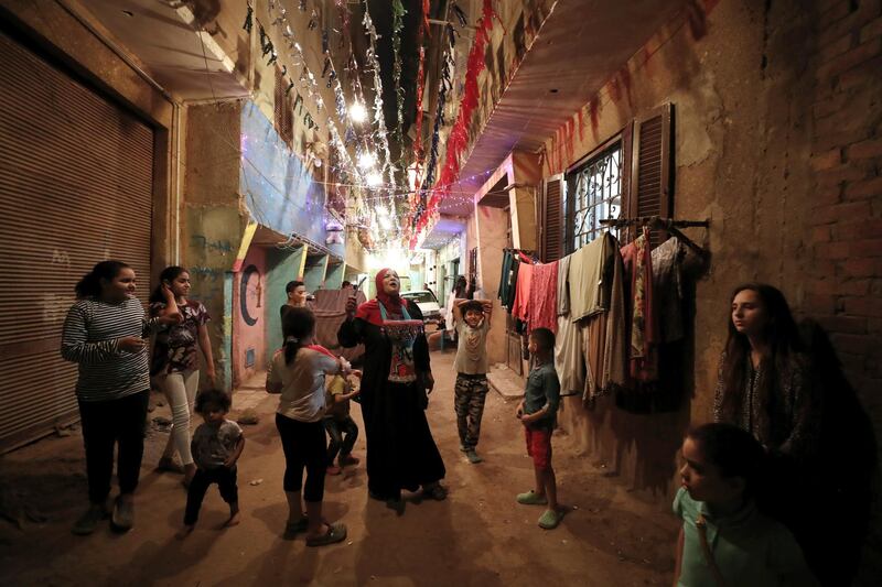 An Egyptian 'Mosahrati', or late night waker, bangs her drums and calls out to the Muslim faithful around the Maadi neighbourhood before dawn in Cairo, Egypt. EPA