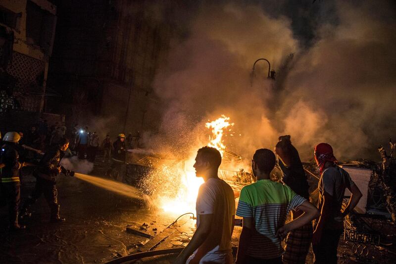 People extinguish a fire from a blast outside the National Cancer Institute, Cairo, Egypt. EPA