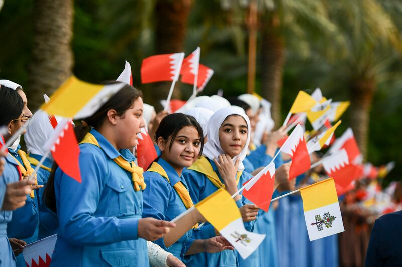 Schoolchildren prepare to welcome Pope Francis at Sakhir Palace. Khushnum Bhandari / The National 