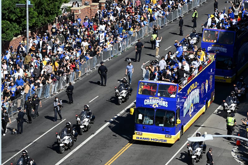 Buses carrying Los Angeles Rams players and coaches drive past fans during the team's victory parade. AP