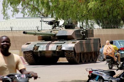 People drive past a Chad army tank near presidential palace, as fighters from the rebel Front for Change and Concord in Chad (FACT) appeared to be moving toward the capital according to the United States, in N'djamena, Chad April 19, 2021. REUTERS/ Stringer       NO RESALES. NO ARCHIVES.