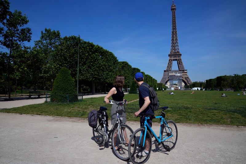 Cyclists take a look at the Eiffel Tower in Paris. AP Photo