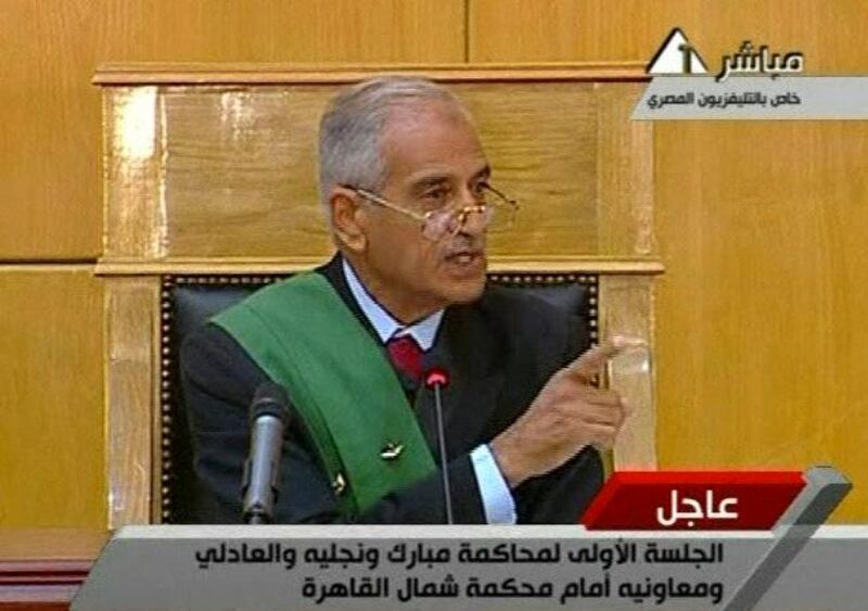 This video image taken from Egyptian State Television shows the judge Ahmed Rifast gestures during the trial of ailing, 83-year-old Hosni Mubarak,  his two sons and other officals at the start of his historic trial Wednesday on charges of corruption and ordering the killing of protesters during the uprising that toppled him in a Cairo courtroom Wednesday Aug. 3, 2011 as his historic trial began on charges of corruption and ordering the killing of protesters during the uprising that ousted him. The scene, shown live on Egypt's state TV, was Egyptians' first look at their former president since Feb. 10, the day before his fall when he gave a defiant speech refusing to resign.   (AP Photo/Egyptian State TV)   EGYPT OUT *** Local Caption ***  Egypt Mubarak Trial.JPEG-0b966.jpg