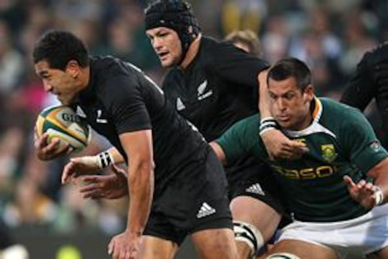 New Zealand's Mils Muliaina, leftt, tries to avade the clutches of South Africa's Pierre Spies during their Tri-Nations match in Bloemfontein, South Africa, last Saturday.