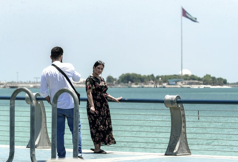 Abu Dhabi, United Arab Emirates, July 15, 2019.  Standalone weather images.  Tourists at the Corniche pose in front of the UAE flag.
Victor Besa/The National
Section:  NA
Reporter: