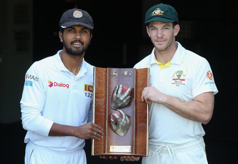 BRISBANE, AUSTRALIA - JANUARY 23: Ski Lankan captain Dinesh Chandimal and Australian captain Tim Paine pose with the Warneâ€“Muralidaran trophy ahead of the Test match between Australia and Sri Lanka at The Gabba on January 23, 2019 in Brisbane, Australia. (Photo by Jono Searle/Getty Images)