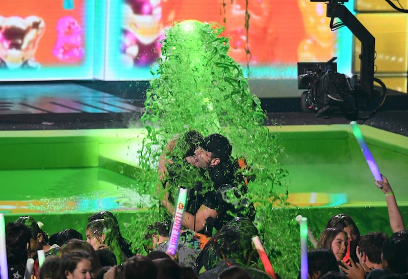 Favourite Social Star winner Slovakian YouTuber David Dobrik, left, and actor Josh Peck get slimed on stage. AFP