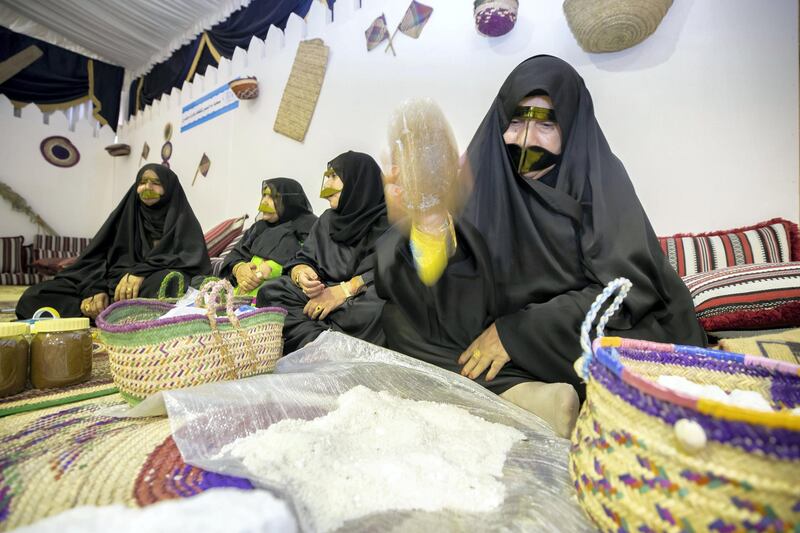 Dibba, United Arab Emirates - June 26, 2019: A lady crushes salt. Al Hosn fish salting festival. Wednesday the 26th of June 2019. Dibba. Chris Whiteoak / The National