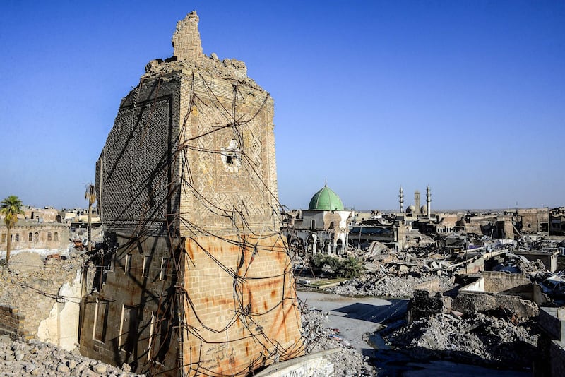 TOPSHOT - A picture taken on July 9, 2018 shows a view of the base of the destroyed "Al-Hadba" leaning minaret, with the dome of the destroyed Al-Nuri Mosque seen behind in the Old City of Mosul, a year after the city was retaken by the Iraqi government forces. Iraqi forces announced the "liberation" of the country's second city on July 10, 2017, after a bloody nine-month offencive to end the Islamic State (IS) group's three-year rule there. Scores of people are still displaced in and around Mosul as the city lies in ruins, one year after it was retaken from IS.  / AFP / Zaid AL-OBEIDI
