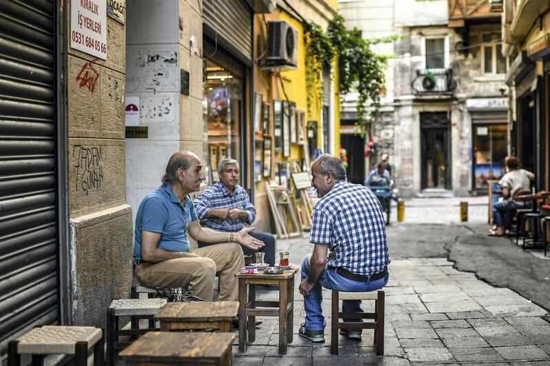 Men chat as they drink tea on June 22, 2018 in Istanbul. - Turkey is preparing for tight presidential and parliamentary elections due on June 24, while many analysts say President Erdogan wants a major foreign policy success to give him a final boost. (Photo by Aris MESSINIS / AFP)