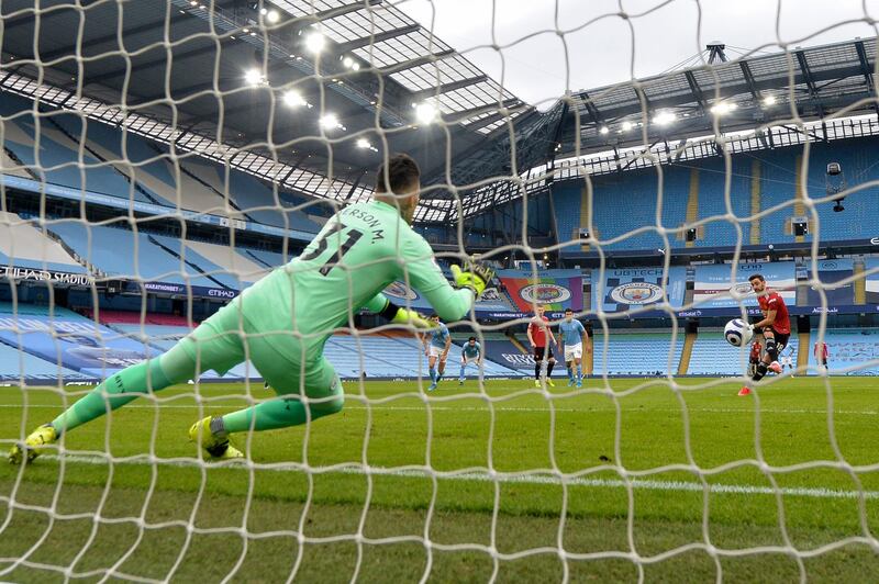 Manchester United's Bruno Fernandes, right, scores the opening goal from the penalty spot past City goalkeeper Ederson at the Etihad Stadium. AP