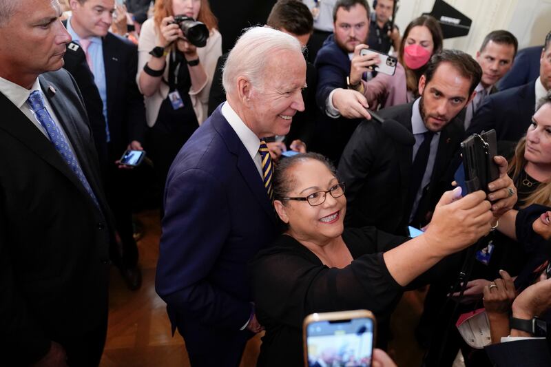 Mr Biden poses for a selfie after signing the bill. AP