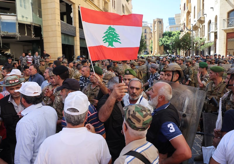 A demonstrator holds a Lebanese flag during the protest. Reuters