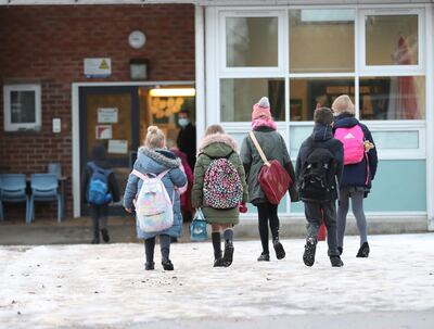 Pupils arrive at Manor Park School and Nursery in Knutsford, England, as schools across England return after the Christmas break, Monday,  Jan. 4, 2021. Britain's Prime Minister Boris Johnson on Sunday insisted he has â€œno doubtâ€ that schools are safe and urged parents to send their children back into the classroom Monday in areas of England where schools plan to reopen. (Martin Rickett/PA via AP)