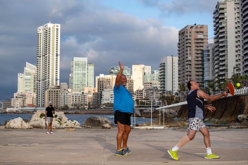 A man welcomes his friend after weeks of a national lockdown in Lebanon to curb the spread of the coronavirus as he plays paddleball at Beirut's seaside promenade, along the Mediterranean Sea. AP Photo