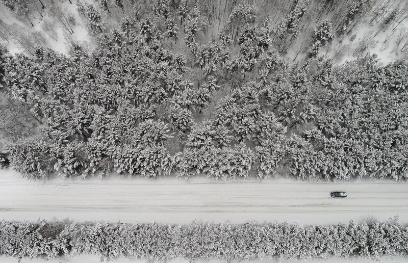 A car drives along a forest road after snowfall outside Krasnoyarsk, Russia. Ilya Naymushin / Reuters