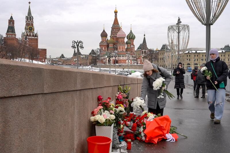People lay flowers at the site of Russian opposition leader Boris Nemtsov being shot dead on a bridge near the Kremlin, Moscow, on the ninth anniversary of his killing. AFP
