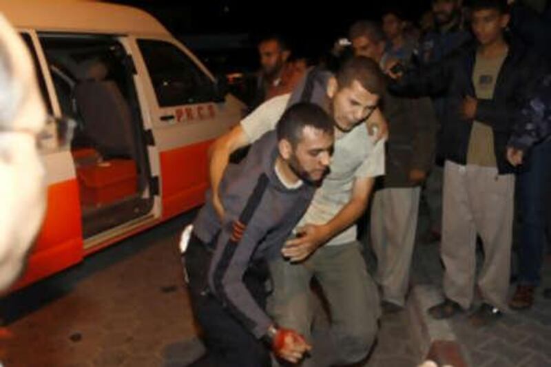 A Palestinian helps a wounded man to the al-Aqsa hospital in Deir al-Balah, central Gaza strip, on November 4, 2008. A Palestinian fighter was killed and three other militants were wounded on November 4, 2008 in a shootout with an Israeli army unit in the Gaza Strip near the border with Israel, Palestinian medical officials said. AFP PHOTO / MAHMUD HAMS   *** Local Caption ***  635906-01-08.jpg