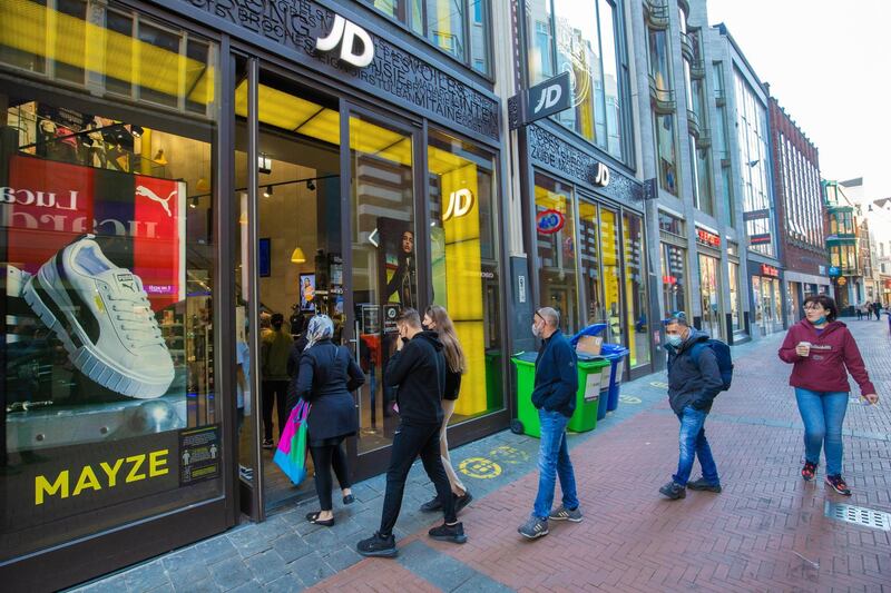 Customers queue for access to a JD Sports store in Amsterdam, the Netherlands. Shops and outdoor seating at restaurants and cafes have partially reopened. Bloomberg