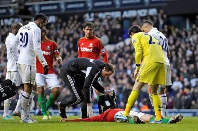 Michu, the Swansea City forward, lies motionless on the pitch after a collision with Tottenham goalkeeper Hugo Lloris, right. Jonathan Brady / PA