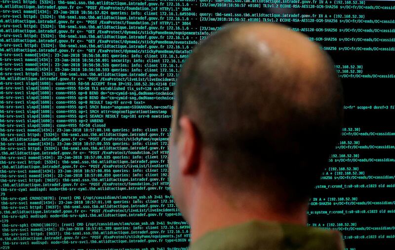 FILE - In this file photo taken on Jan. 23 2018, a solider watches code lines on his computer screen at the French Defense ministry stand during the International Cybersecurity forum in Lille, northern France. France has flagged more than 78,000 people as security threats in a database intended to let European police share information on the continent's most dangerous residents _ more than all other European countries put together _ according to an analysis by The Associated Press. (AP Photo/Michel Spingler, File)