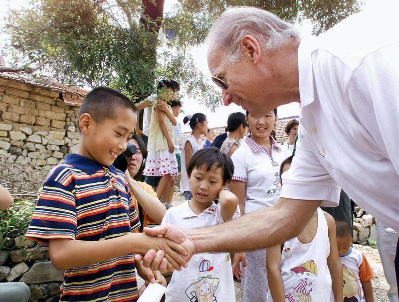 US Senate Foreign Relations Committee Chairman Joseph Biden (R) shakes hands with seven-year-old Gao Shan, the boy Biden proclaimed as the future president of China, during a visit to the village of Yanzikou, north of Beijing, 10 August 2001.  After meeting Chinese leaders for two days, Biden and his delegation left Beijing to look at life in the countryside, where 70 percent of China's population lives.    AFP PHOTO/POOL (Photo by GREG BAKER / POOL / AFP)