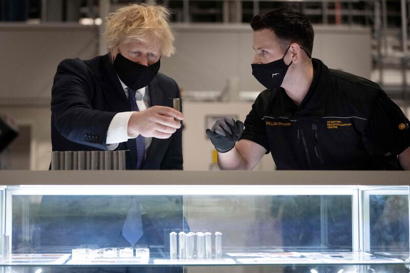 Britain's Prime Minister Boris Johnson looks at a single battery cell during a visit to the UK Battery Industrialisation Centre in Coventry. AFP