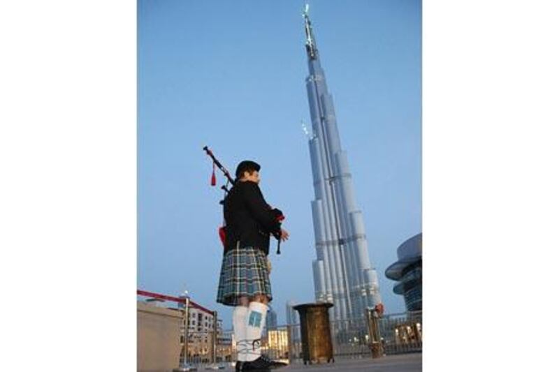 A lone piper plays below the Burj Khalifa in Dubai to commemorate Anzac Day last year.