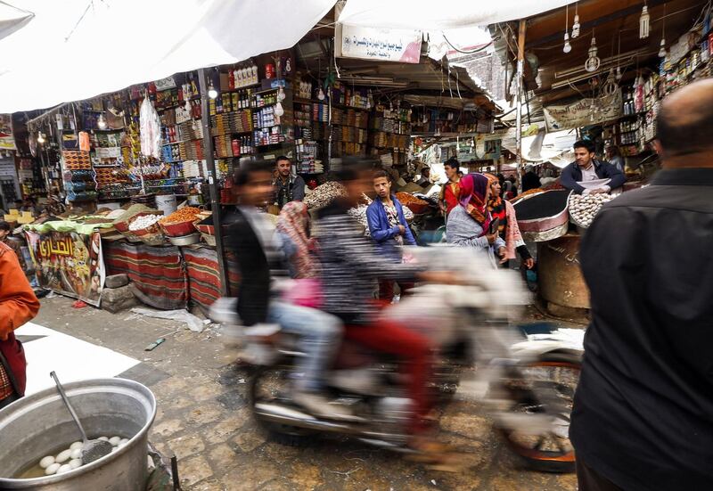 TOPSHOT - Yemenis ride in a motorcycle down an alley in the market in the old city of the capital Sanaa on February 15, 2018. / AFP PHOTO / MOHAMMED HUWAIS