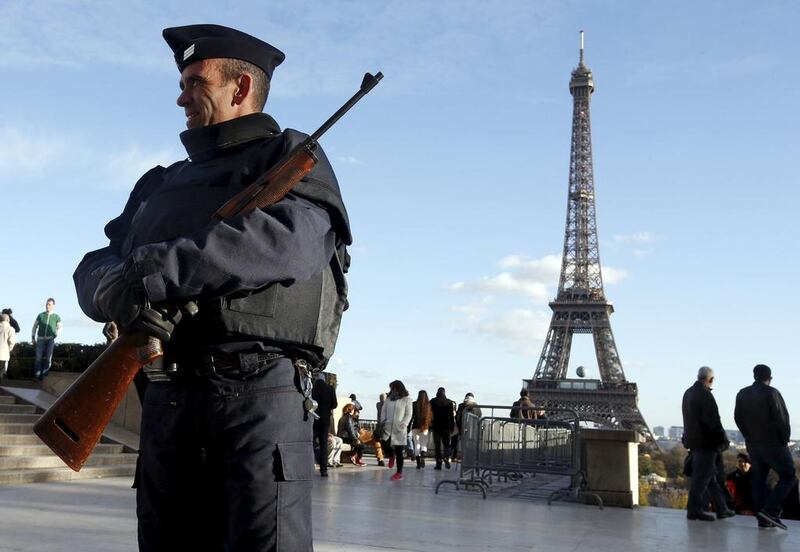 A French police officer stands guard by the Eiffel tower a week after a series of deadly attacks in the French capital Paris (REUTERS/Eric Gaillard)