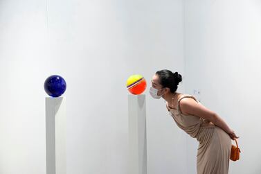 A visitor peers at an artwork by Helen Pashgian at Art Basel in Hong Kong in May. The Swiss part of the major art fair is expected to go ahead in September. AP