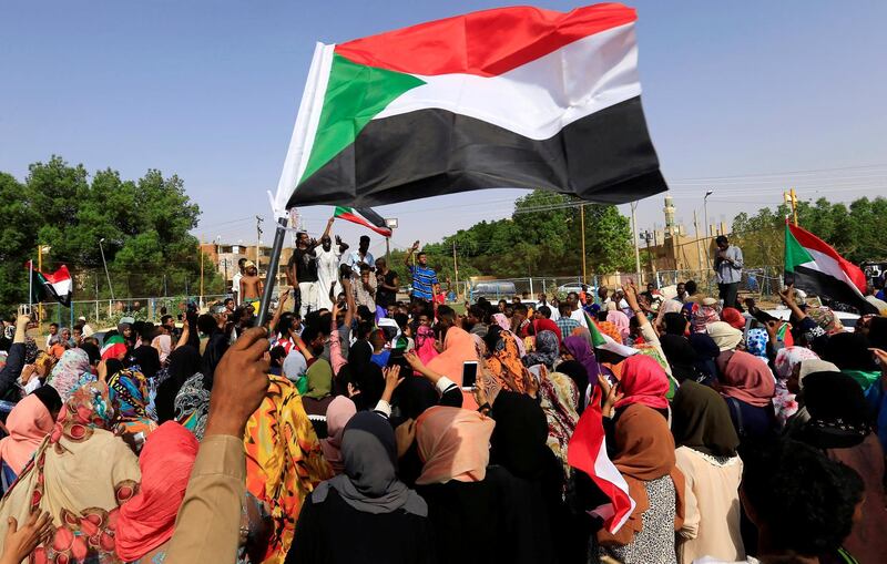 FILE PHOTO: Sudanese people chant slogans and wave their national flag as they celebrate, after Sudan's ruling military council and a coalition of opposition and protest groups reached an agreement to share power during a transition period leading to elections, along the streets of Khartoum, Sudan, July 5, 2019. REUTERS/Mohamed Nureldin Abdallah/File Photo