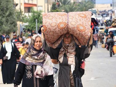 TOPSHOT - Palestinians flee the area of Tal al-Sultan in Rafah with their belongings following renewed Israeli strikes in the city in the southern Gaza Strip on May 28, 2024, amid the ongoing conflict between Israel and the Palestinian Hamas militant group. (Photo by Eyad BABA / AFP)