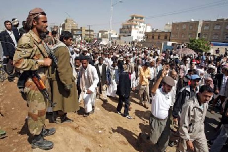 Yemeni defected army soldiers, left, stand guard on a street where protestors march during a demonstration demanding the resignation of Yemeni President Ali Abdullah Saleh in Sanaa, Yemen, Thursday, Nov. 10, 2011. (AP Photo/Hani Mohammed) *** Local Caption ***  Mideast Yemen.JPEG-03a46.jpg