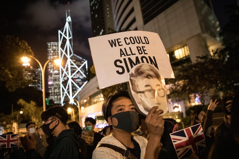 A protester holds a mask featuring the face of former UK Consulate employee Simon Cheung with the words "We Could All Be Simon" featured above during a petition protest outside the British Consulate General in Hong Kong, China. Protesters gathered to put pressure on the British Government to take action after Cheung announced during a TV interview that he had been tortured whilst detained for 15 days on a business trip to mainland China in August. Getty Images