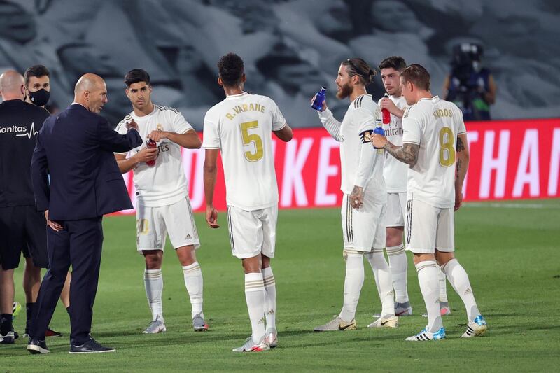 Coach Zinedine Zidane talks with his players during a drinks break. EPA